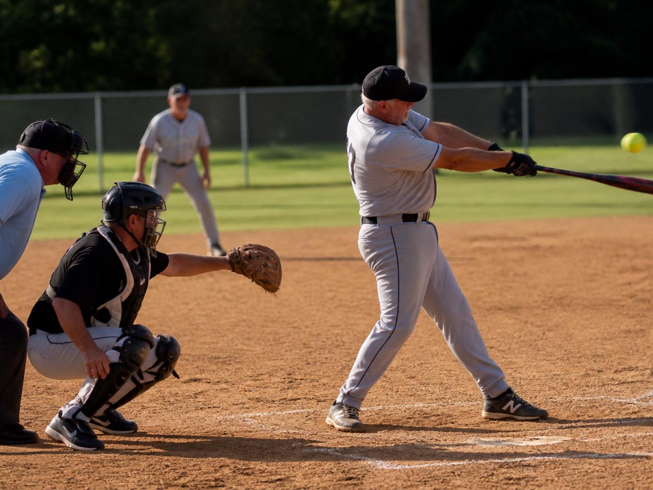 Big swing at the plate under the late afternoon sun.